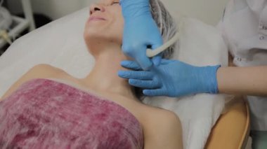Profesyonel bir Kozmetolog bir kadın güzellik salonunda yüz temizleme vakum yapar. Kozkolojik yenilikler.