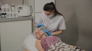 Profesyonel bir Kozmetolog bir kadın güzellik salonunda yüz temizleme vakum yapar. Kozkolojik yenilikler.