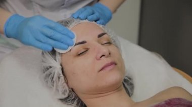 Bir kadın güzellik salonunda özel mendiller ile temizlenir.