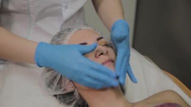 Kadın Spa salonunda yüz masajı yapıyor.