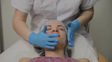 Kadın Spa salonunda yüz masajı yapıyor.