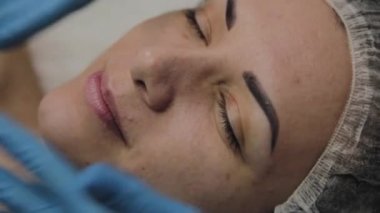 Kadın Spa salonunda yüz masajı yapıyor.