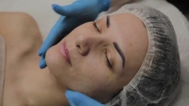 Kadın Spa salonunda yüz masajı yapıyor.