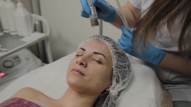 Een professionele schoonheidsspecialist maakt een vrouw vacuüm reinigen van het gezicht in een schoonheidssalon. Cosmetische innovaties. — Stockvideo