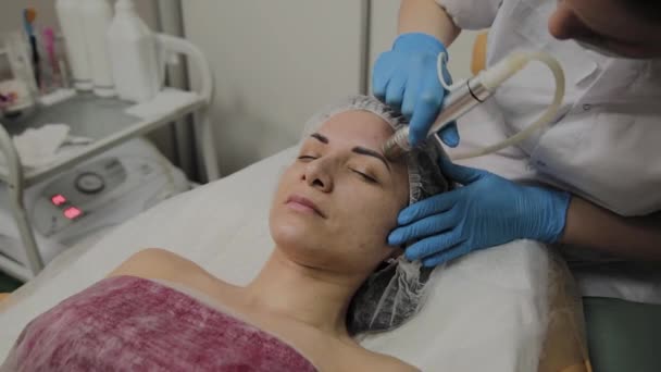 Un cosmetologo professionista rende una donna aspirapolvere il viso in un salone di bellezza. Innovazioni cosmetologiche . — Video Stock