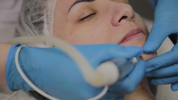 Um cosmetologista profissional faz uma mulher aspirar limpar o rosto em um salão de beleza. Inovações cosmológicas . — Vídeo de Stock