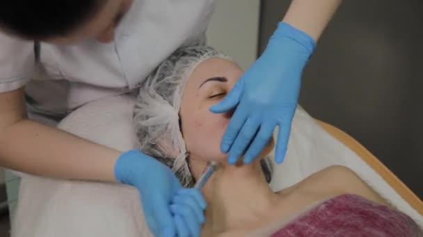 Eine professionelle Kosmetikerin lässt eine Frau in einem Schönheitssalon das Gesicht staubsaugen. Kosmetologische Innovationen. — Stockvideo