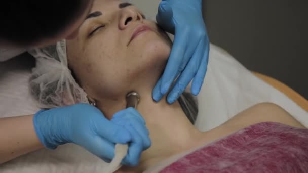 Un cosmetologo professionista rende una donna aspirapolvere il viso in un salone di bellezza. Innovazioni cosmetologiche . — Video Stock
