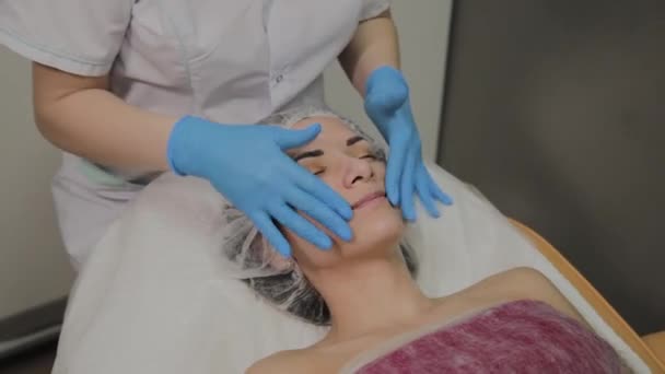 Mulher fazendo massagem facial no salão de spa . — Vídeo de Stock