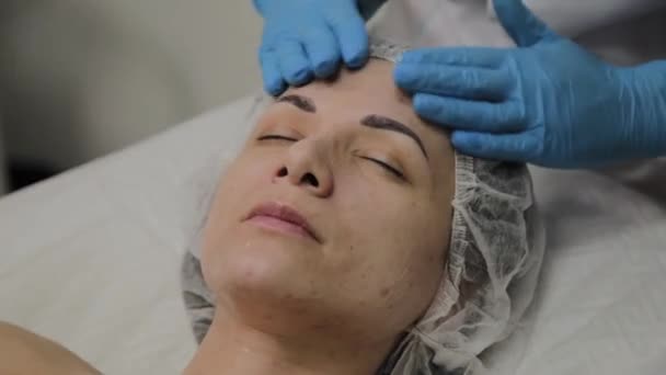 Vrouw doet gezicht massage in de spa salon. — Stockvideo