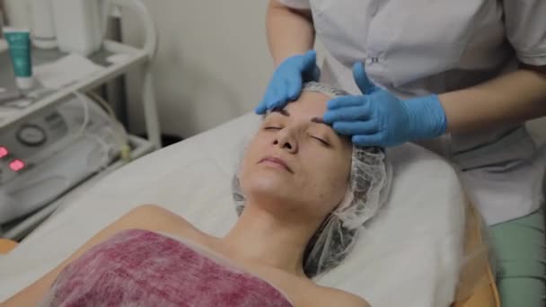 Mujer haciendo masaje facial en el salón de spa . — Vídeos de Stock