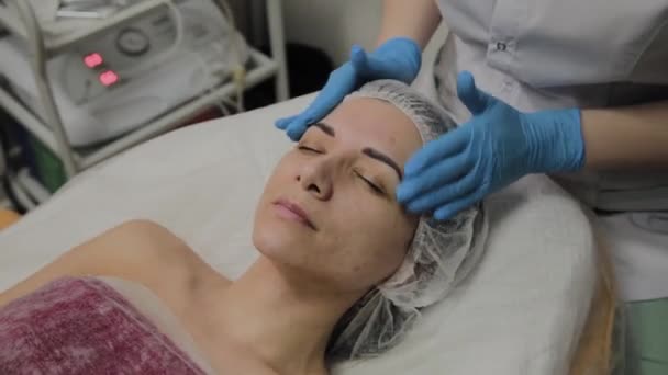 Mujer haciendo masaje facial en el salón de spa . — Vídeos de Stock