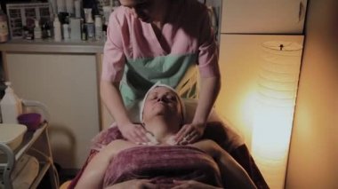 Profesyonel bir güzellik prosedürü için yaşlı bir kadının yüzünü hazırlar. Kozkolojik yenilikler