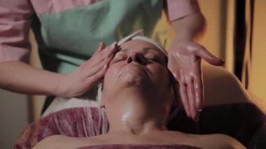 Profesyonel Kozmetolog yaşlı bir kadına masaj yapar. Kozkolojik yenilikler