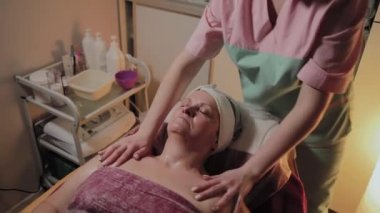 Profesyonel Kozmetolog yaşlı bir kadına masaj yapar. Kozkolojik yenilikler