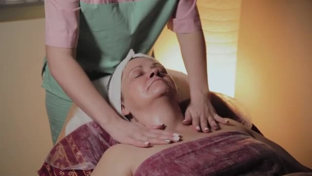 Professionele schoonheidsspecialist maakt massage aan een oudere vrouw. Cosmetische innovaties — Stockvideo