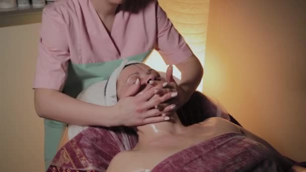 Profesjonalny kosmetolog sprawia, że masaż do starszej kobiety. Innowacje kosmetyczno-kosmetyczne — Wideo stockowe