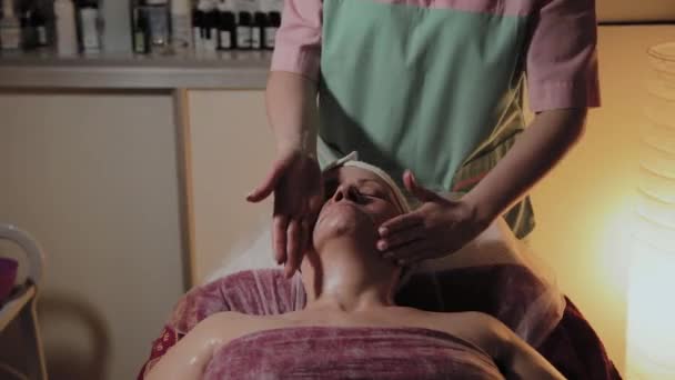 Cosmetologist profissional faz a massagem a uma mulher idosa. Inovações cosmológicas — Vídeo de Stock