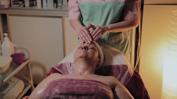전문 미용사가 노인 여성에 게 마사지를 합니다. 미용 학적 혁신 — 비디오