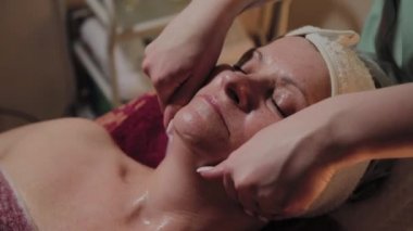 Profesyonel Kozmetolog yaşlı bir kadına masaj yapar. Kozkolojik yenilikler