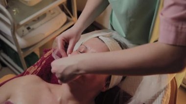 Profesyonel Kozmetolog yaşlı bir kadına masaj yapar. Kozkolojik yenilikler