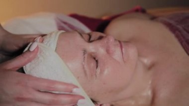 Profesyonel Kozmetolog yaşlı bir kadına masaj yapar. Kozkolojik yenilikler