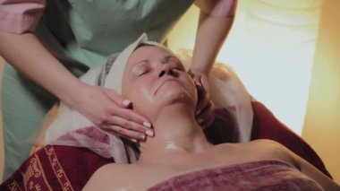 Profesyonel Kozmetolog yaşlı bir kadına masaj yapar. Kozkolojik yenilikler