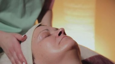 Profesyonel Kozmetolog yaşlı bir kadına masaj yapar. Kozkolojik yenilikler