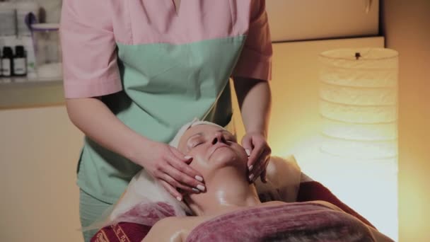 Cosmétologue professionnel fait massage à une femme âgée. Innovations cosmétologiques — Video