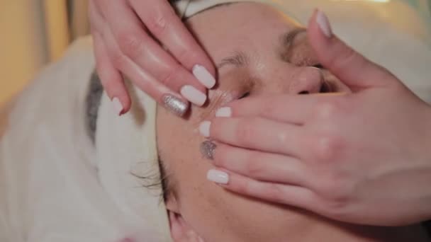 Cosmetólogo profesional hace masajes a una mujer mayor. Innovaciones cosmetológicas — Vídeo de stock