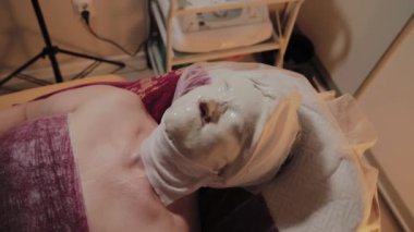 Bakımlı yaşlı kadın bir güzellik salonunda prosedürü bir maske giyiyor.