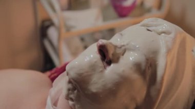 Bakımlı yaşlı kadın bir güzellik salonunda prosedürü bir maske giyiyor.