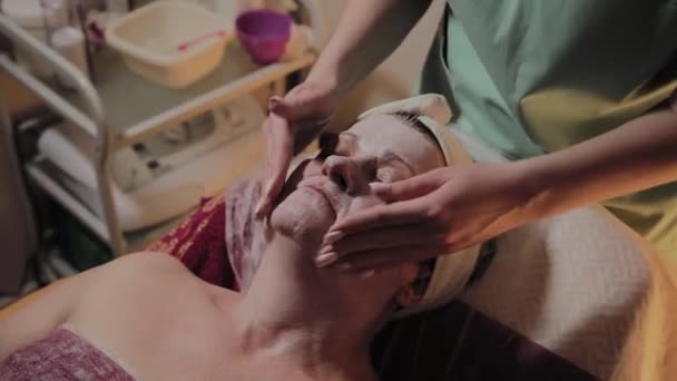 Cosmetólogo profesional hace masajes a una mujer mayor. Innovaciones cosmetológicas — Vídeos de Stock