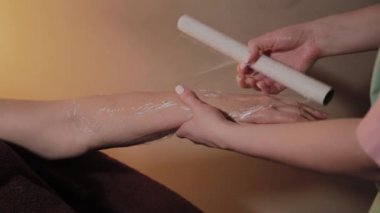 el masaj sonrası yaşlı bir kadın tarafından selofan sarılmış eller.