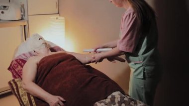 el masaj sonrası yaşlı bir kadın tarafından selofan sarılmış eller.