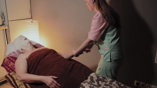 Профессиональный массаж рук пожилой женщины в салоне красоты . — стоковое видео