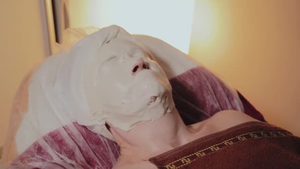 Καλά-καλλωπισμένο ηλικιωμένη γυναίκα φοράει μια μάσκα στη διαδικασία σε ένα σαλόνι ομορφιάς. — Αρχείο Βίντεο