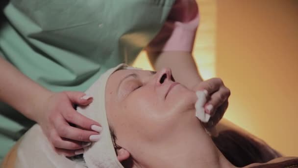 Una esteticista profesional prepara el rostro de una anciana para el procedimiento. Innovaciones cosmetológicas — Vídeos de Stock