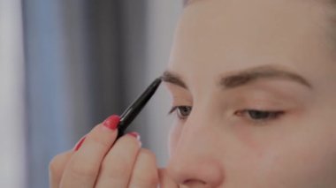 Makyaj sanatçısı güzel bir genç kıza profesyonel makyaj uygular. Makyaj yeni konsept.