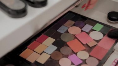 Bir palet göz gölgeler ve makyaj fırça ile: kadın kozmetik. Sabah makyaj. Dekoratif kozmetik: bir palet ile göz gölgeler, bir fırça. Akşam makyaj. Makyaj sanatçıları ayrıntılarını çalışmak.