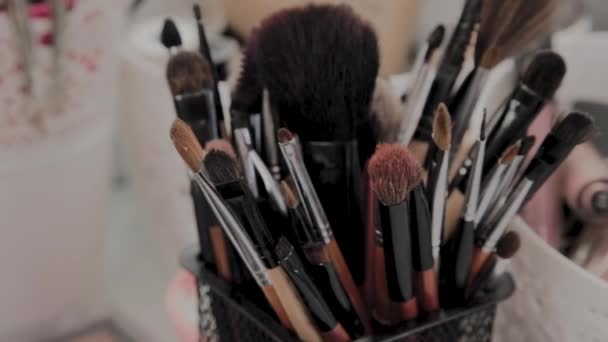 Un conjunto de pinceles para el maquillaje en el artista de maquillaje de mesa . — Vídeos de Stock