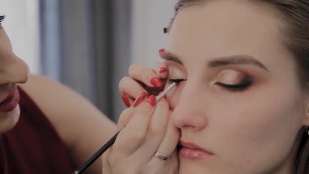Make-up Artist past professionele make-up om een mooi jong meisje. Nieuw concept in make-up. — Stockvideo