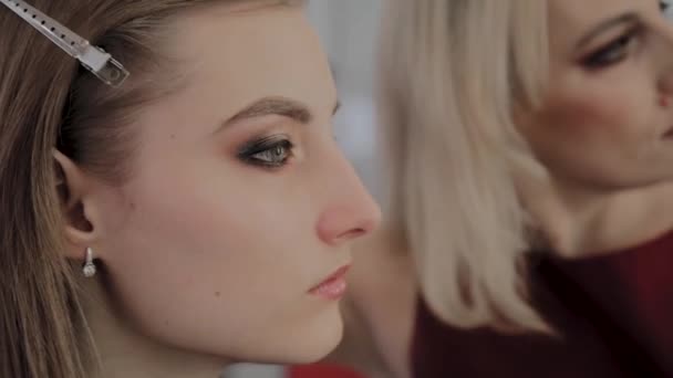 Makeup artist applica il trucco professionale a una bella ragazza. Nuovo concetto di trucco . — Video Stock