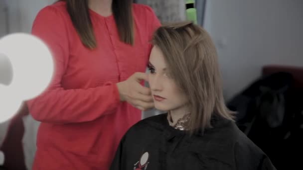 Peluquería profesional hace un peinado de chicas para una sesión de fotos . — Vídeo de stock