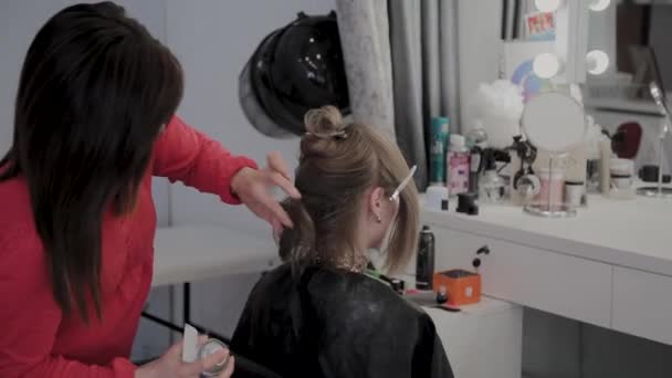 Cabeleireiro profissional faz um penteado meninas para uma sessão de fotos . — Vídeo de Stock