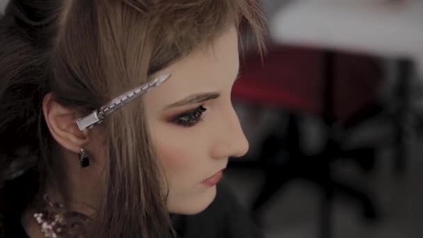 Junges Mädchen mit Haarnadel im Haar in einem Friseursalon. — Stockvideo