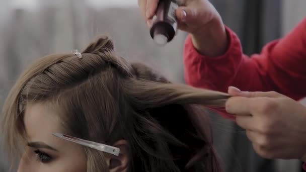 Professional hairdresser does a girls hairstyle for a photo shoot. — Stock Video