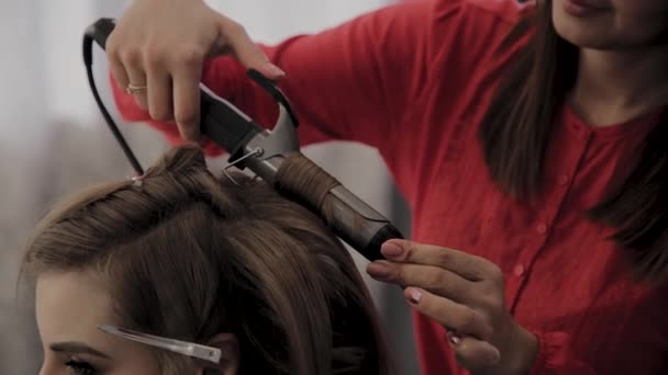 Cabeleireiro profissional faz um penteado meninas para uma sessão de fotos . — Vídeo de Stock