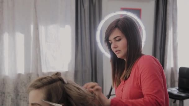 Coiffeur professionnel fait une coiffure de filles pour une séance photo . — Video