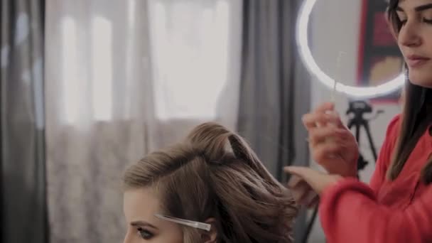 Coiffeur professionnel fait une coiffure de filles pour une séance photo . — Video